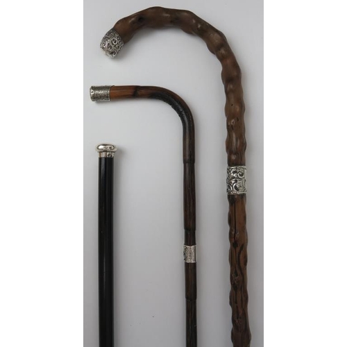 114 - Three Victorian and Edwardian walking canes. Comprising a Victorian crook handled gnarled wood walki... 