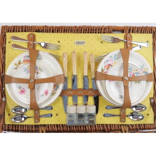 129 - A English vintage Sirram picnic hamper set. Comprising flasks, containers, plates and cutlery housed... 