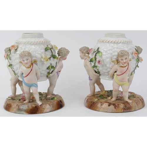 24 - A pair of German Dresden porcelain oil lamp stands. Both modelled depicting three equidistant cherub... 