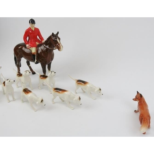 55 - A Beswick ceramic fox hunting set. Comprising a huntsman, ten hunting dogs, and a fox. (12 items) Ho... 