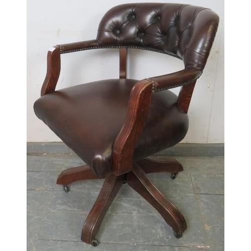 702 - An antique style oak captain’s swivel desk chair with height adjust, upholstered in soft brown butto... 