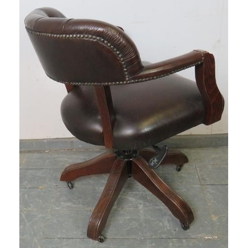 702 - An antique style oak captain’s swivel desk chair with height adjust, upholstered in soft brown butto... 