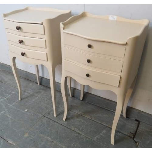 726 - A near pair of vintage French bedside cabinets painted cream, each with ¾ gallery and housing three ... 