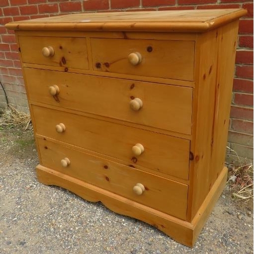 729 - A pine chest of two short over three long drawers with turned wooden handles, on a plinth base with ... 