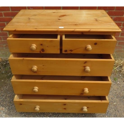 729 - A pine chest of two short over three long drawers with turned wooden handles, on a plinth base with ... 