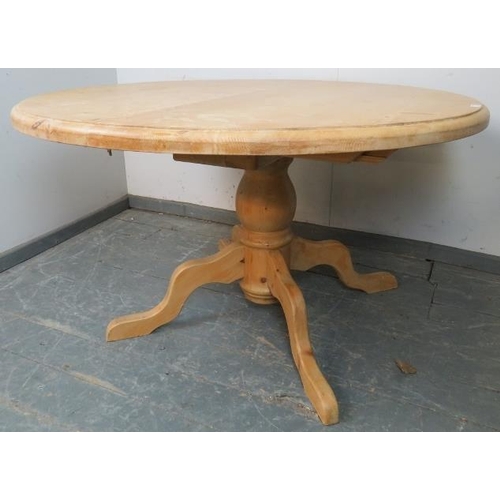 732 - A stripped pine circular extending kitchen table, with additional central leaf, on a baluster turned... 