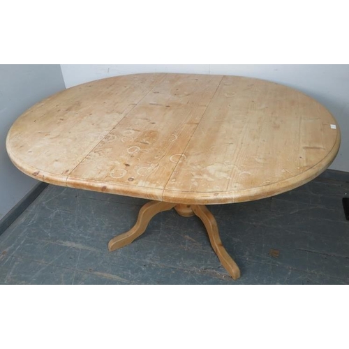 732 - A stripped pine circular extending kitchen table, with additional central leaf, on a baluster turned... 