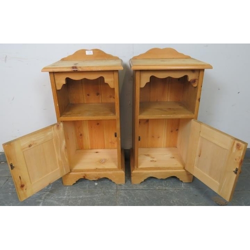 739 - A pair of pine bedside cabinets with shaped galleries, above an open shelf with cupboard under, on p... 