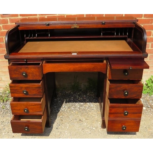 741 - An Edwardian mahogany roll-top desk, the tambour door opening onto a fitted interior, above an array... 