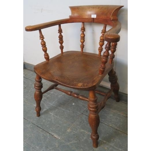 745 - A turn of the century elm smokers bow chair, with turned spindles, on canted turned supports united ... 