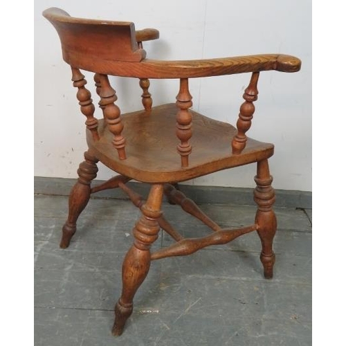 745 - A turn of the century elm smokers bow chair, with turned spindles, on canted turned supports united ... 