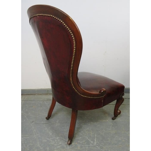 746 - A Victorian mahogany spoonback chair, upholstered in burgundy leather with brass studs, on scrolled ... 