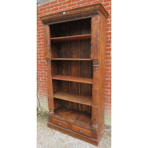 748 - A very large open bookcase of reclaimed antique tropical hardwood, featuring carved frieze and pilas... 