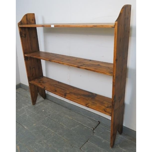 750 - An antique pine open bookcase of three shelves, on stile supports. 
H122cm W122cm D25cm (approx).
Co... 