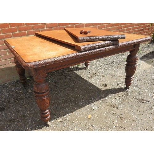 750A - A Victorian medium oak wind-out extending dining table with two individually leaves on carved suppor... 