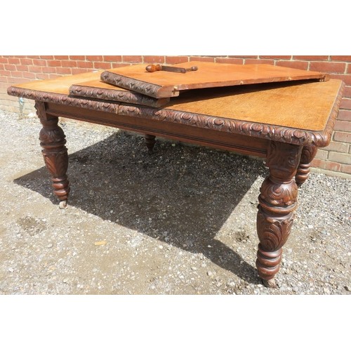 750A - A Victorian medium oak wind-out extending dining table with two individually leaves on carved suppor... 