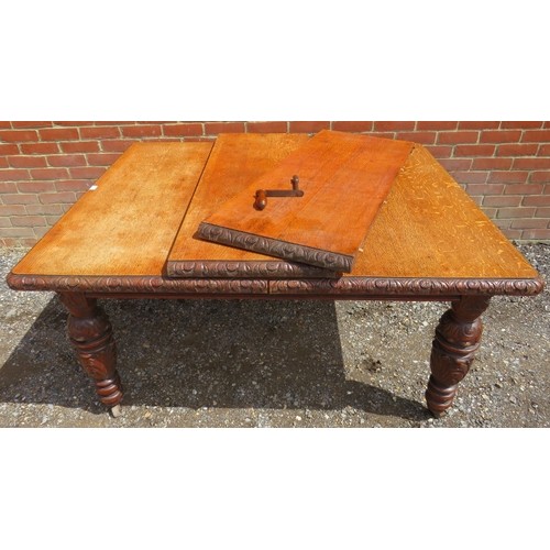 750A - A Victorian medium oak wind-out extending dining table with two individually leaves on carved suppor... 