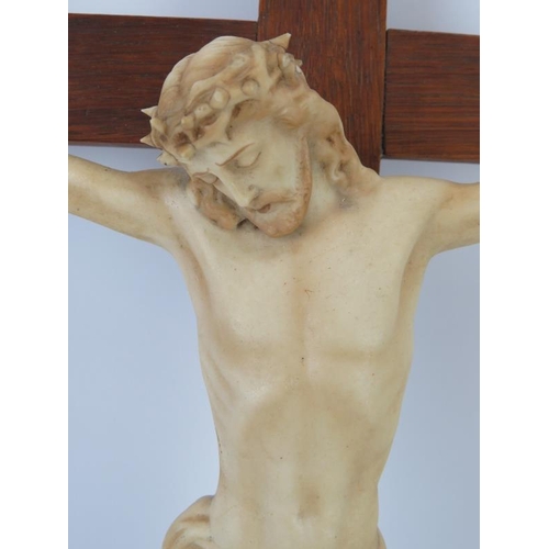 195 - A European ecclesiastical ceramic figure of Jesus on the cross, mid 20th century. Supported on a woo... 