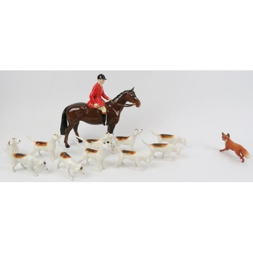 204 - A Beswick ceramic fox hunting set. Comprising a huntsman, ten hunting dogs, and a fox. (12 items) Ho... 