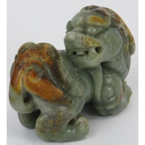 222 - A Chinese celadon and russet jade Buddhistic lion, 20th century. 7 cm length. Provenance: Private co... 