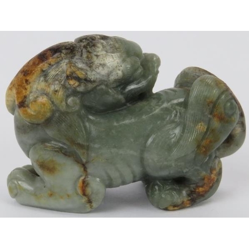 222 - A Chinese celadon and russet jade Buddhistic lion, 20th century. 7 cm length. Provenance: Private co... 