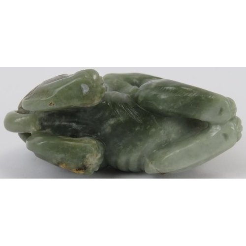 222 - A Chinese celadon and russet jade Buddhistic lion, 20th century. 7 cm length. Provenance: Private co... 