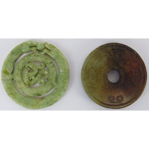 228 - Two Chinese celadon and russet jade carved discs, 20th century. One carved as a bi disc with confron... 