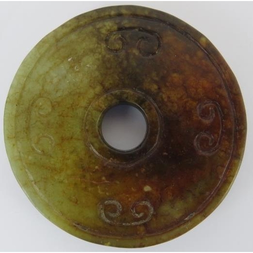 228 - Two Chinese celadon and russet jade carved discs, 20th century. One carved as a bi disc with confron... 