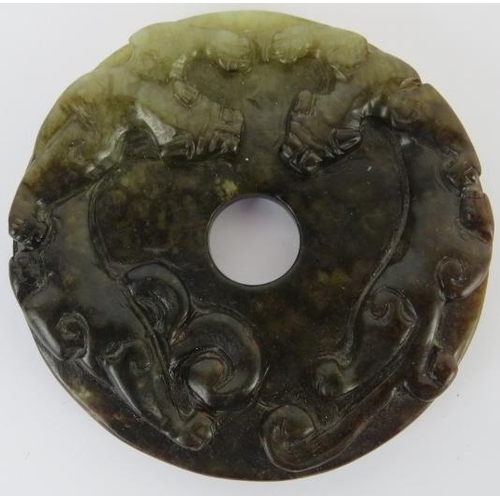 228 - Two Chinese celadon and russet jade carved discs, 20th century. One carved as a bi disc with confron... 