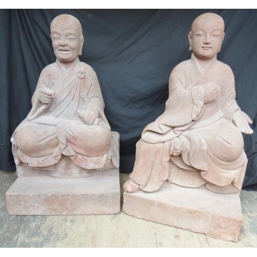 230 - A large architectural pair of Chinese carved red sandstone Luohan guardian monk temple figures. The ... 