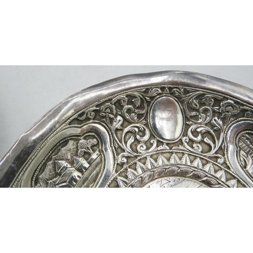 303 - A pair of white Anglo Indian metal dishes heavily embossed with foliate design and cartouche of vill... 