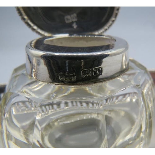 315 - A panel cut glass inkwell with silver top on a silver boat shaped base having pierced decoration. Ba... 