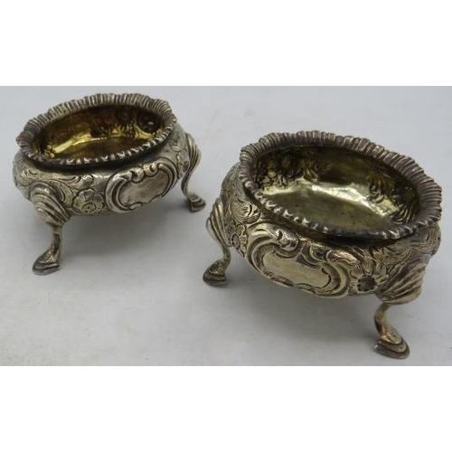 344 - A pair of Victorian circular salts with embossed floral decoration on pad feet and gilded interior, ... 