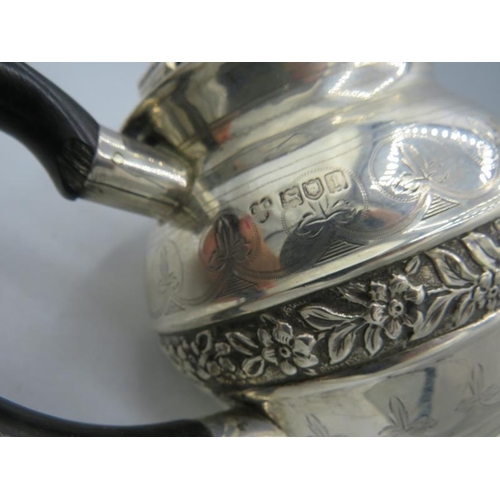 350 - A silver teapot with engraved & embossed decoration, ebonised handle and finial, London 1906. Approx... 