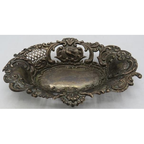 368 - An oval shaped silver bon bon dish with embossed decoration of scrolls & birds and openwork sides, B... 