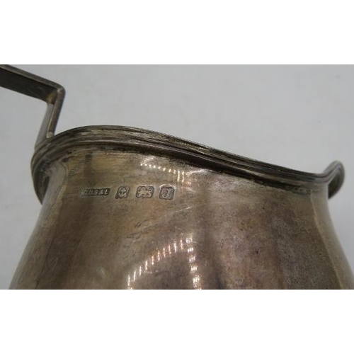 453 - A silver cream jug with applied reeded border & handle, on a flat base, Birmingham 1933. Approx weig... 