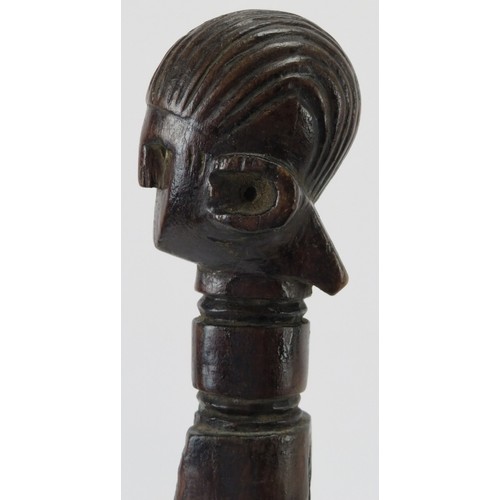 58 - Tribal Art: An African carved hardwood axe handle. One end terminating with a carved head. Displayed... 