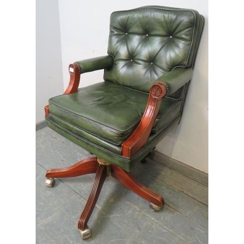 705 - An antique style mahogany swivel desk chair, with height adjust, upholstered in green buttoned leath... 