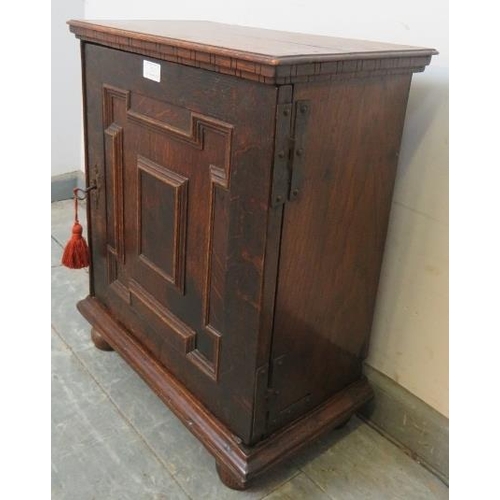 717 - A good 17th century oak spice cupboard, the door with geometric mouldings opening onto a configurati... 