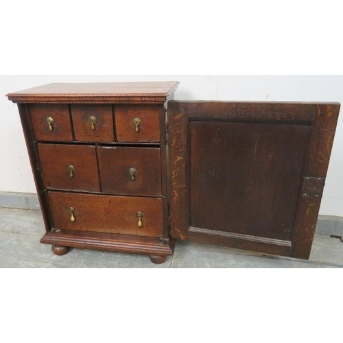 717 - A good 17th century oak spice cupboard, the door with geometric mouldings opening onto a configurati... 