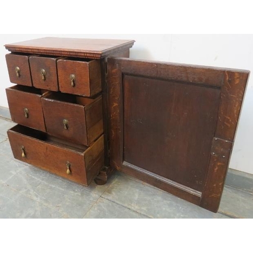 717 - A good 17th century oak spice cupboard, the door with geometric mouldings opening onto a configurati... 