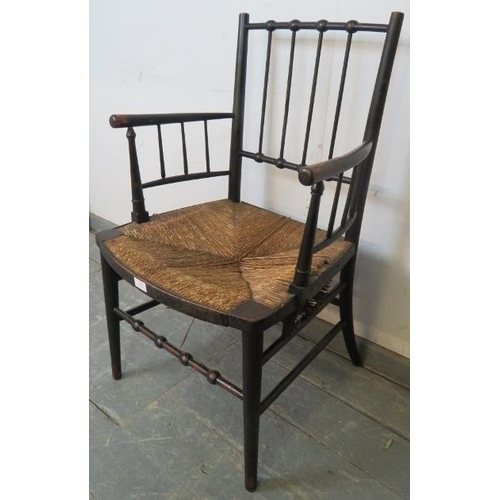 720 - A 19th century ebonised beech William Morris ‘Sussex’ chair, with rush seat, on tapering supports wi... 