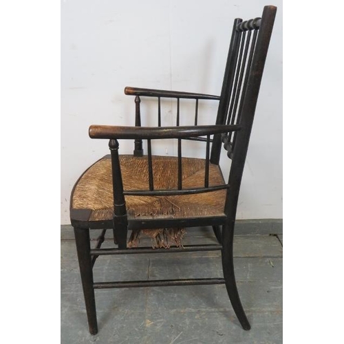 720 - A 19th century ebonised beech William Morris ‘Sussex’ chair, with rush seat, on tapering supports wi... 