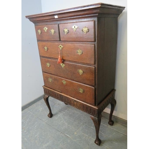 723 - An 18th century oak chest on stand, housing two short over three long drawers with fancy brass lock ... 