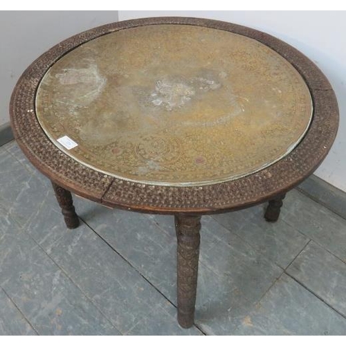 729 - An antique hardwood Anglo Indian Kashmiri folding table, the top with hand-tooled brass tray within ... 