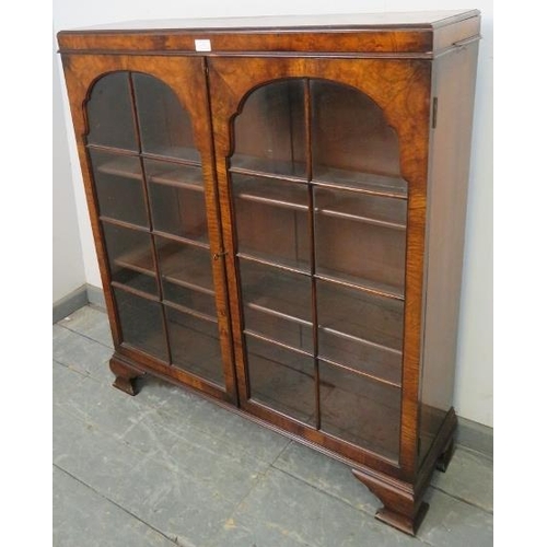 735 - A Georgian style walnut low glazed bookcase, the doors opening onto two height adjustable loose shel... 