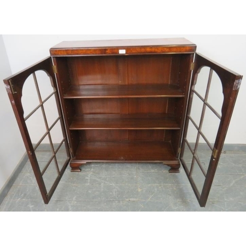 735 - A Georgian style walnut low glazed bookcase, the doors opening onto two height adjustable loose shel... 