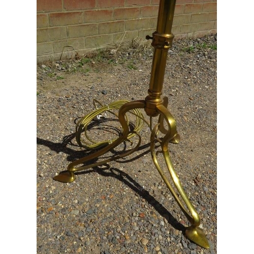 742 - An Arts & Crafts brass height adjustable standard lamp, on a scrolled tripod base with pad feet. 
H1... 