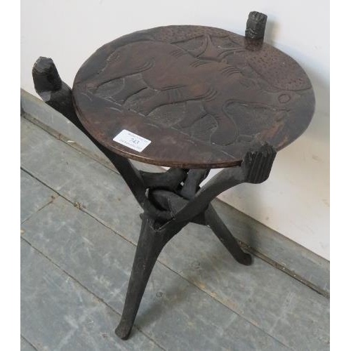 743 - A vintage African tribal occasional table, the reversible top with relief carving depicting wild ani... 