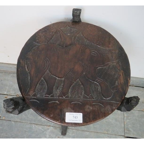 743 - A vintage African tribal occasional table, the reversible top with relief carving depicting wild ani... 